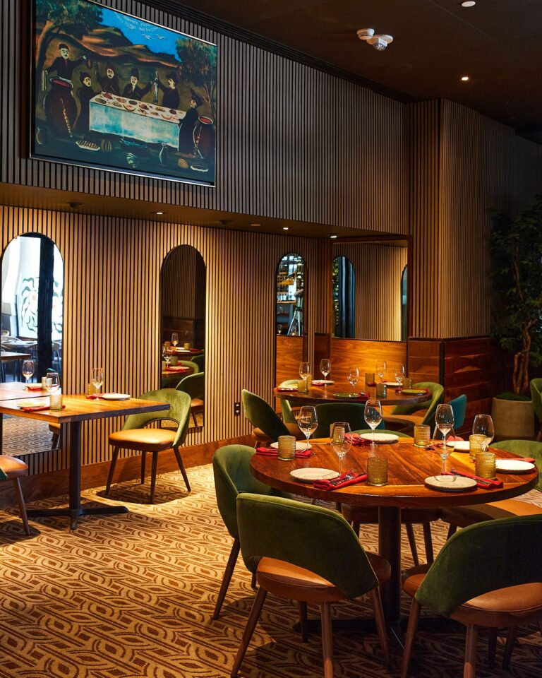 Dining room with a round table, green chairs, and arched windows