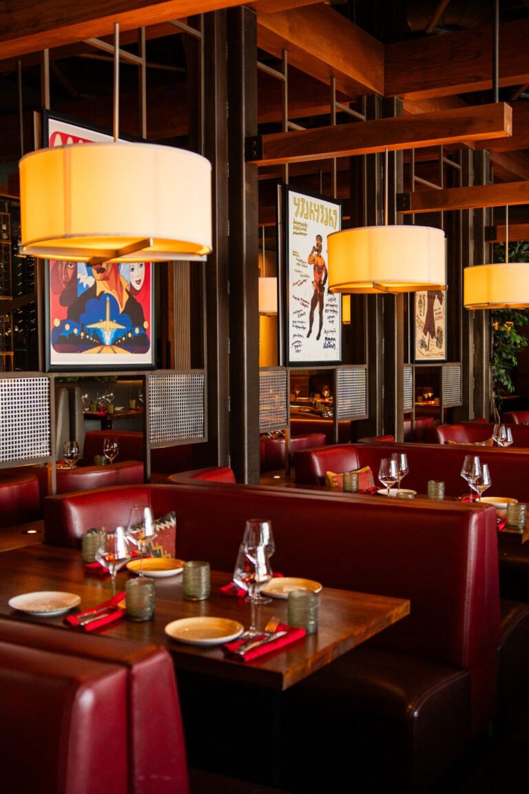 Dining room with red leather booths, pendant lamps, and vintage posters