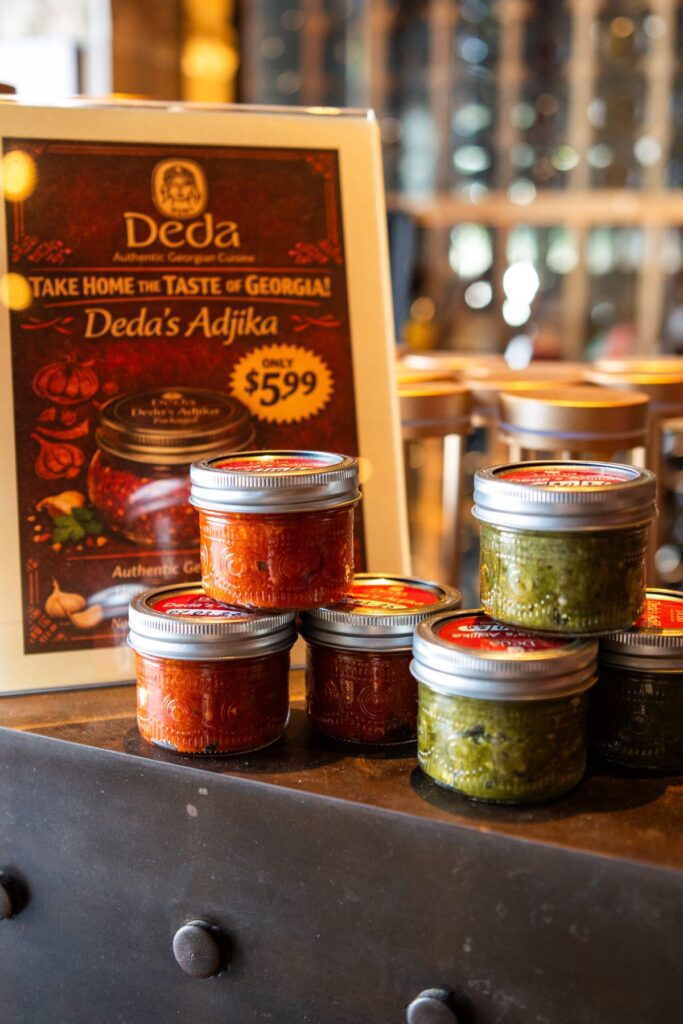 Jars of red and green adjika stacked on a counter